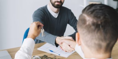 client-shaking-hand-agent-looking-keys