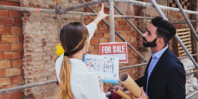 young-real-estate-agents-with-scaffold-background